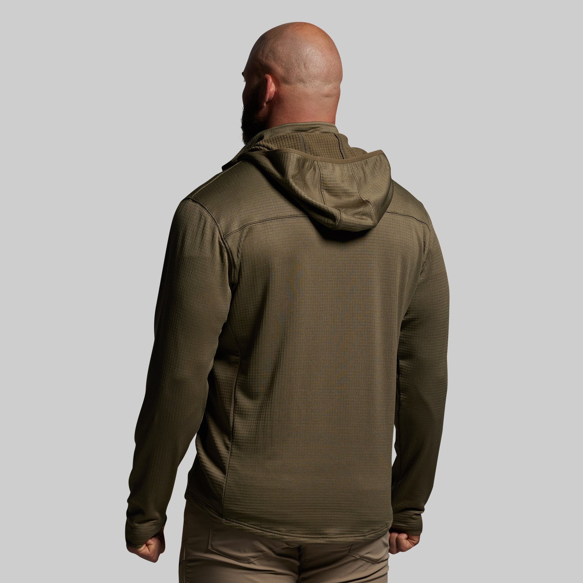 Person wearing a green hoodie on a gray background