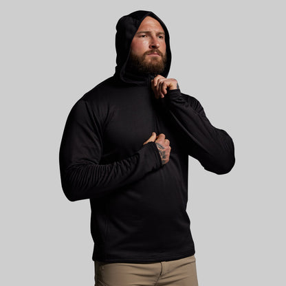 Man wearing a black hoodie against a gray background