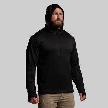 Man wearing a black hoodie against a gray background