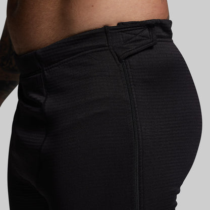 Black pants worn by a person on a gray background
