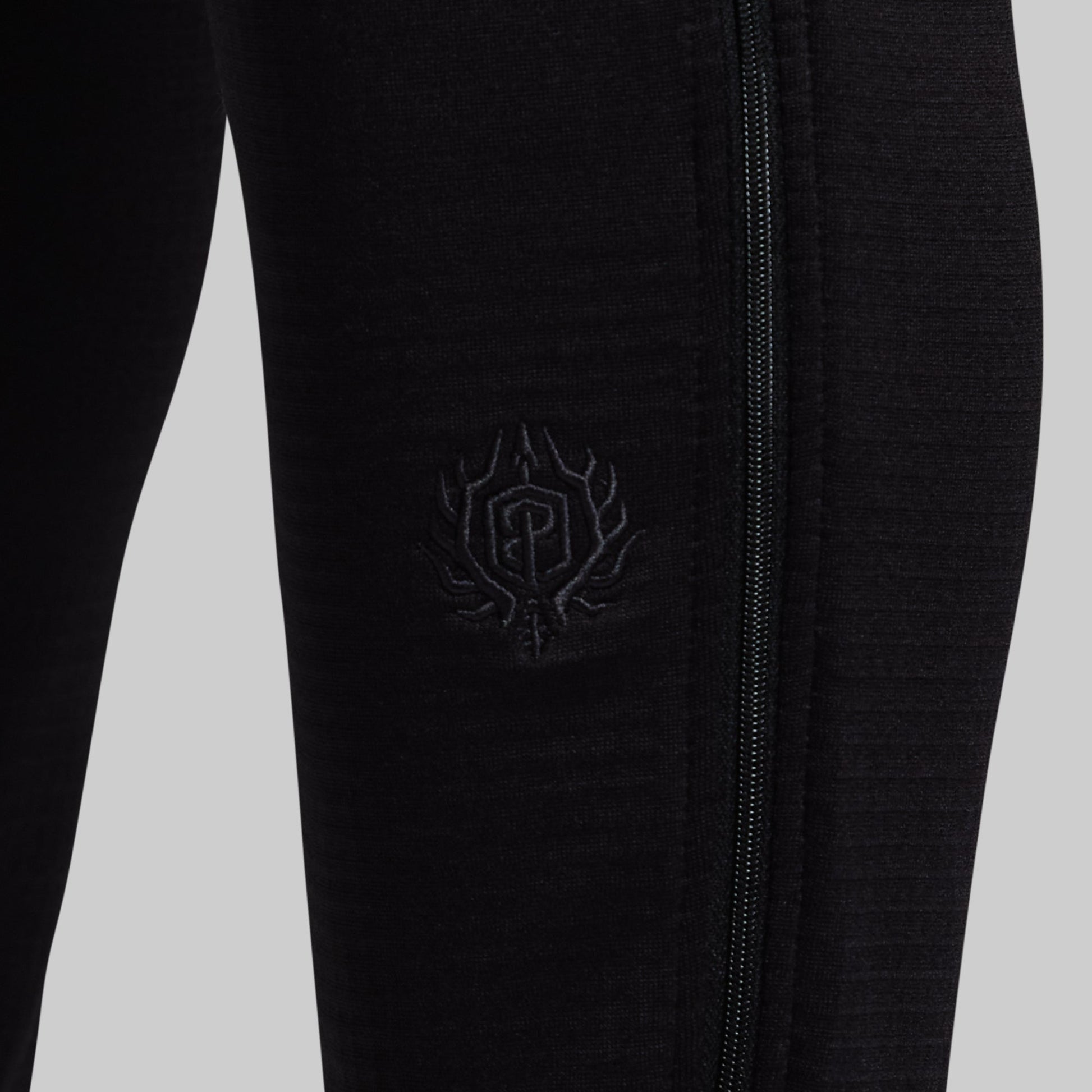 Black pants with a logo against a light gray background