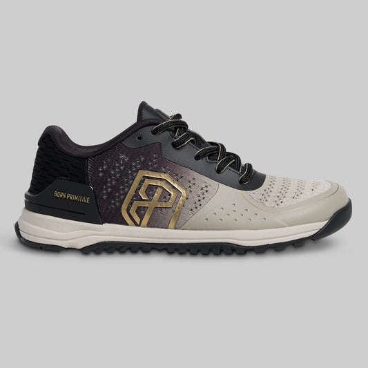 Black and white athletic shoe with gold logo on a gray background