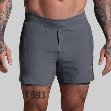 Person wearing gray athletic shorts on a plain background