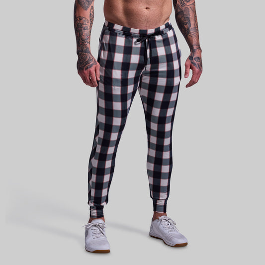 Person wearing black and white checkered pants on a gray background
