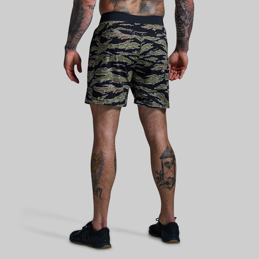 Person wearing camouflage shorts on a plain background