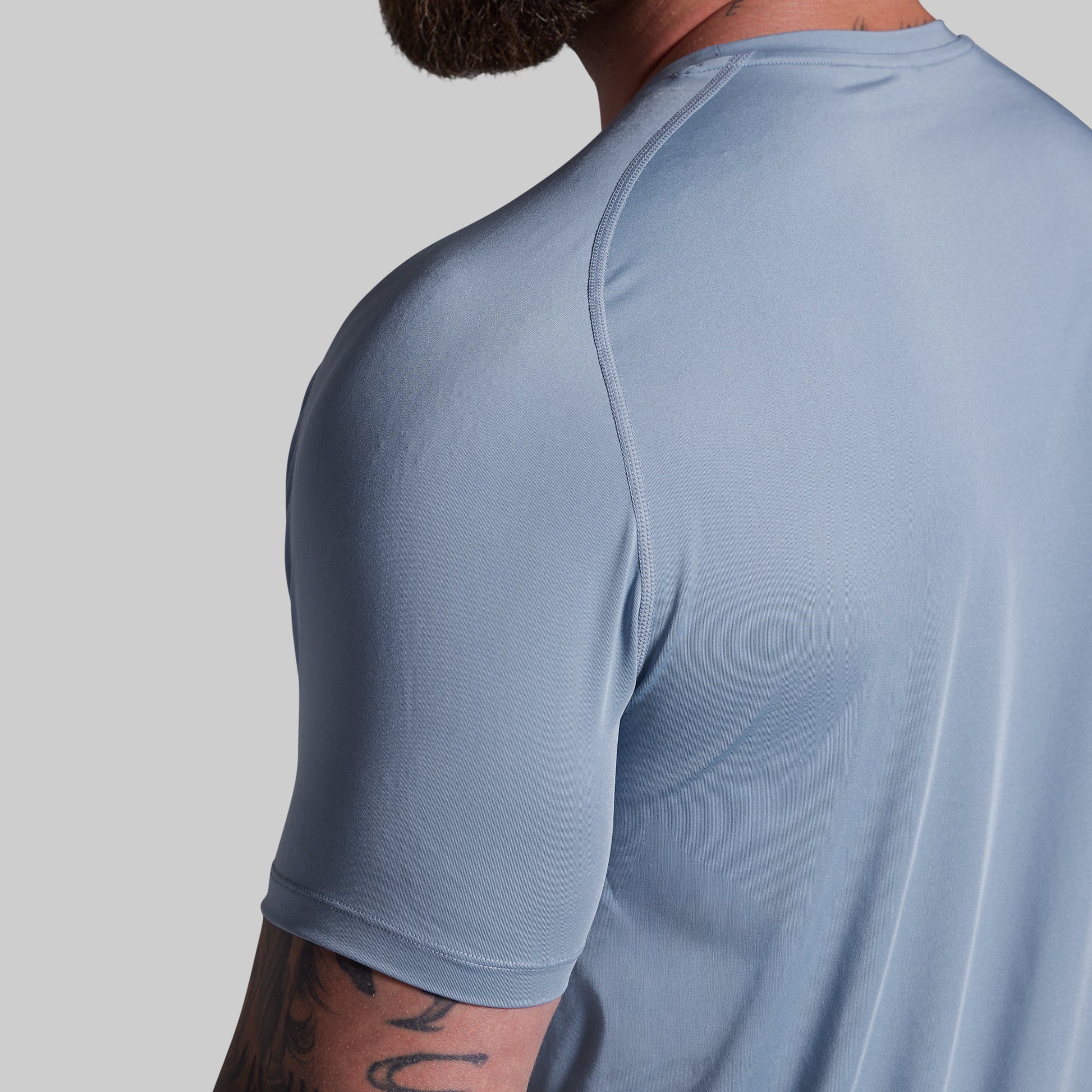 Light blue athletic shirt worn by a person on a gray background