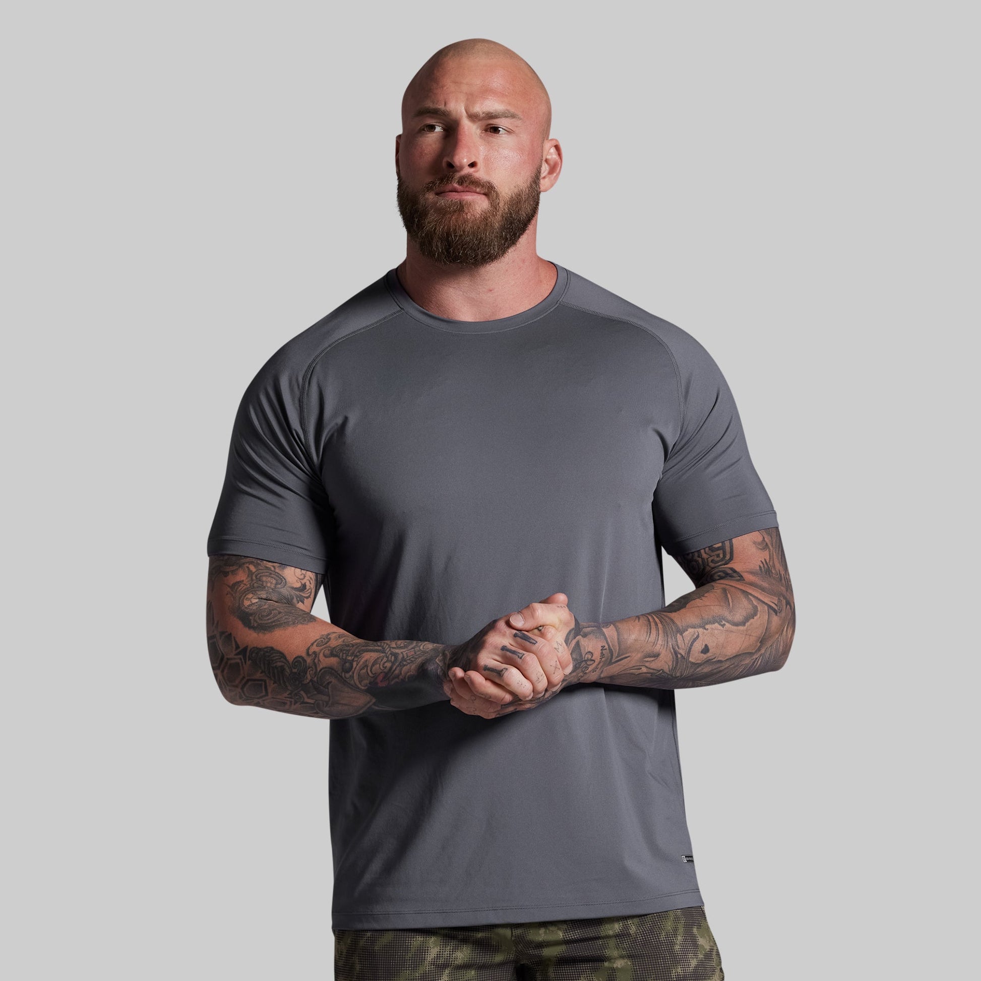 Man wearing a gray t-shirt against a plain background