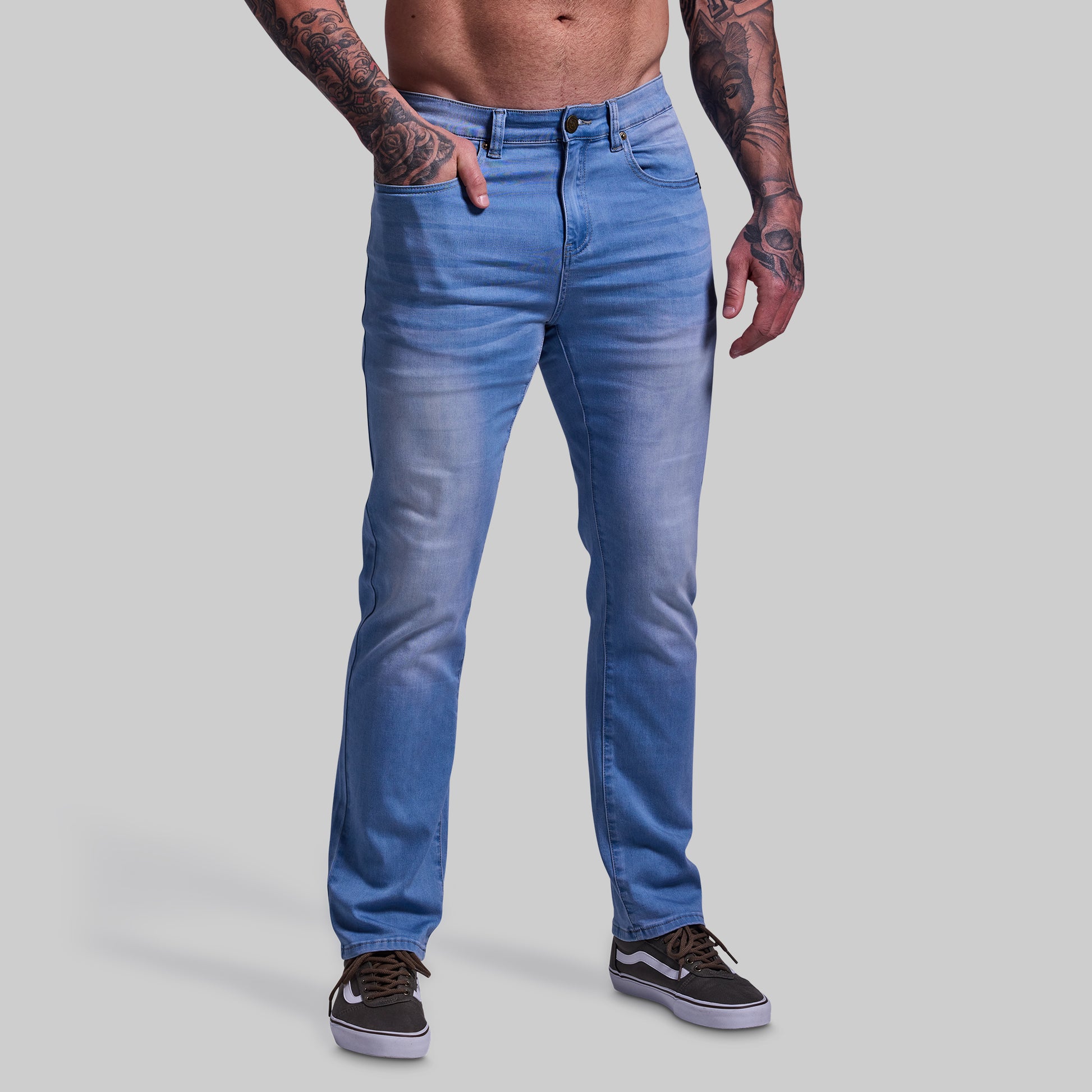 Person wearing blue jeans on a plain background
