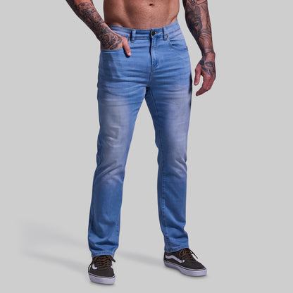 Person wearing blue jeans on a plain background