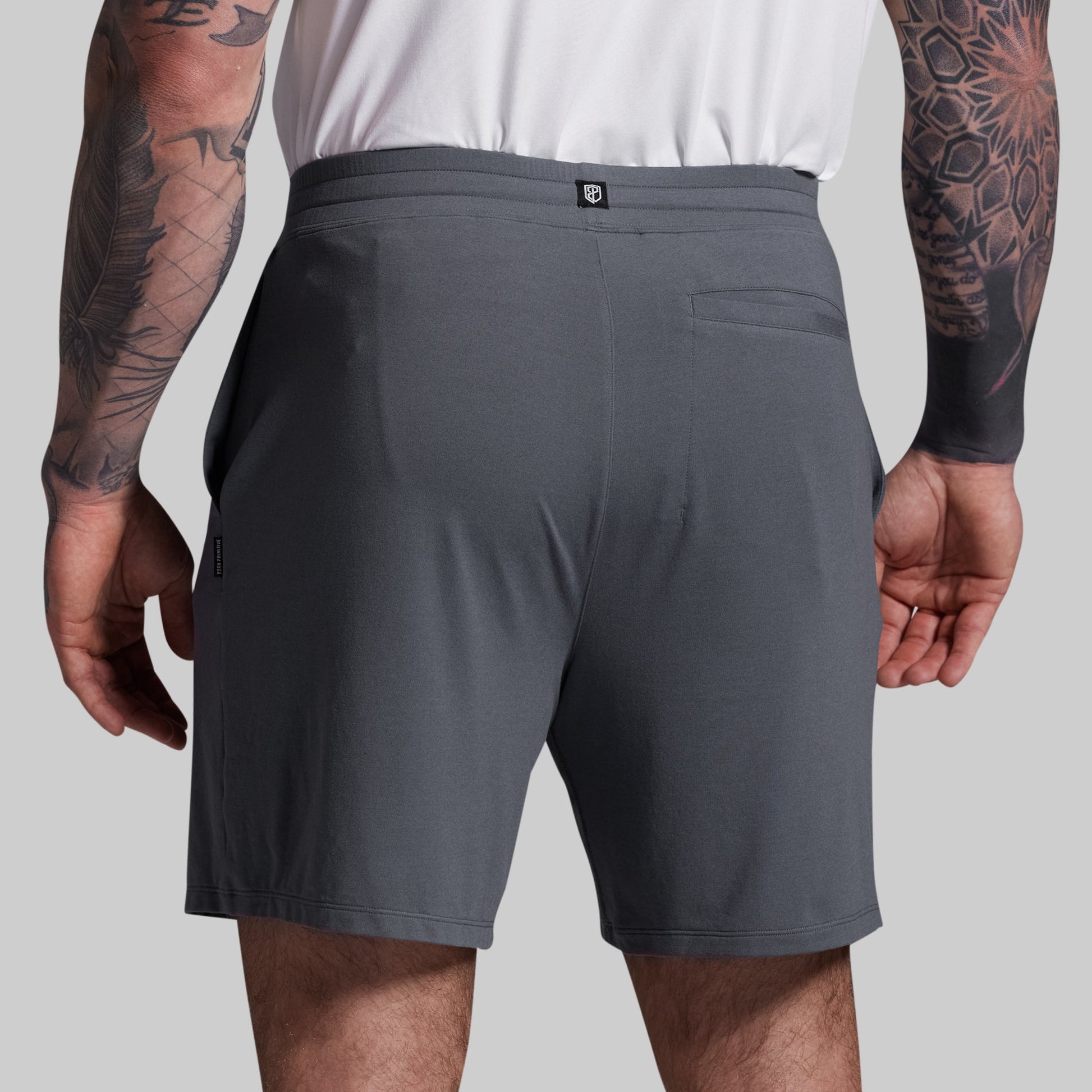 Person wearing gray shorts on a plain background
