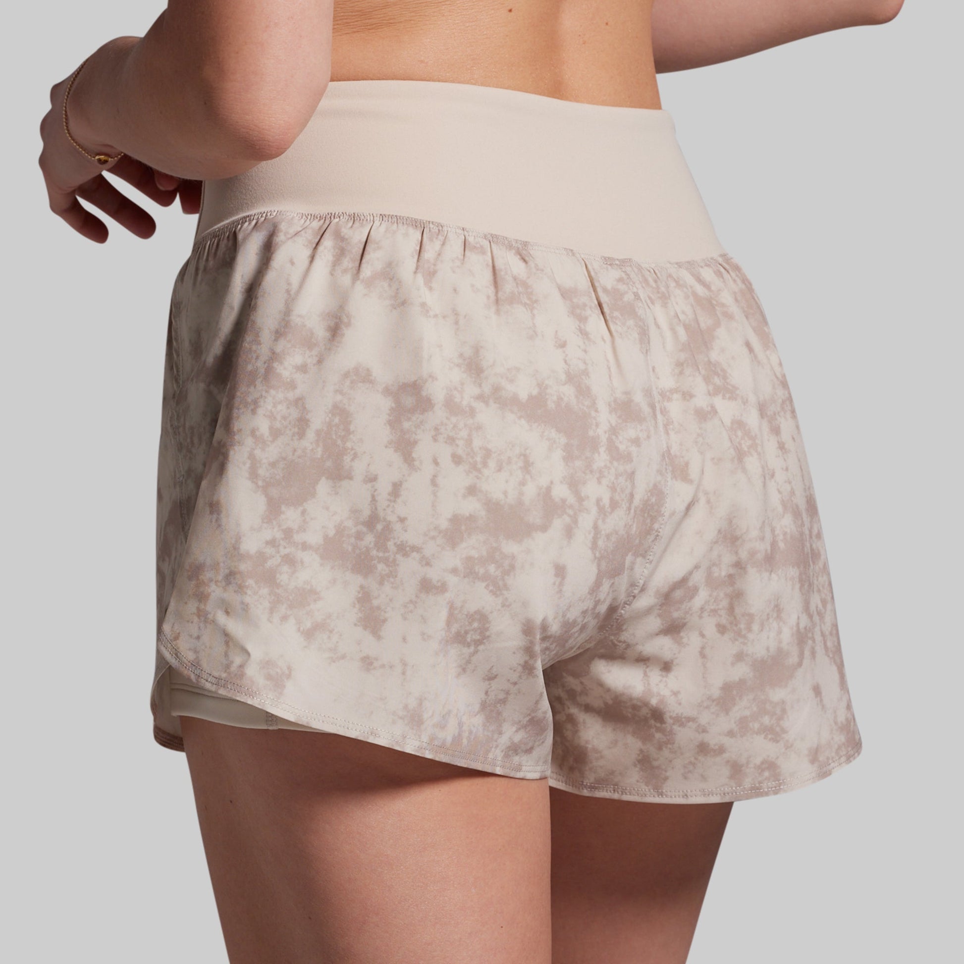 Beige patterned shorts worn by a person on a plain background