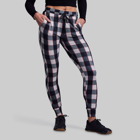Person wearing plaid jogger pants on a gray background