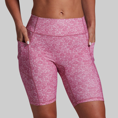Pink patterned shorts worn by a person on a gray background