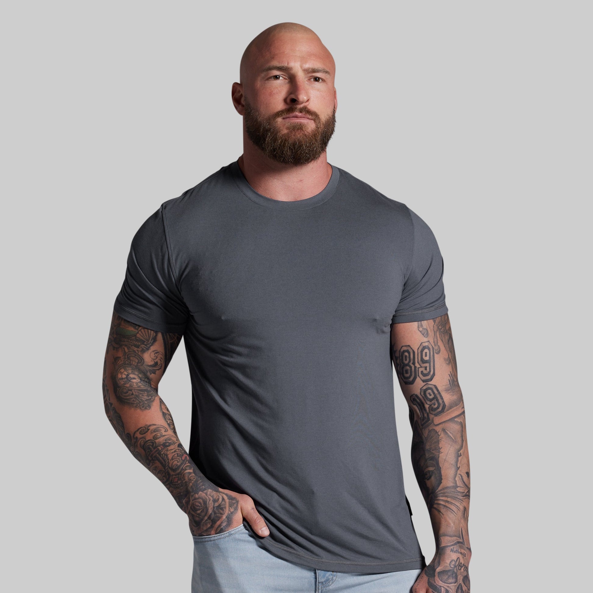 Man wearing a gray t-shirt against a plain background