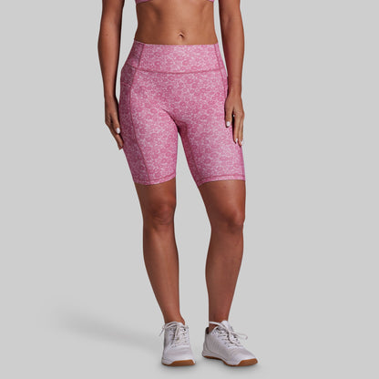 Person wearing pink patterned shorts on a gray background