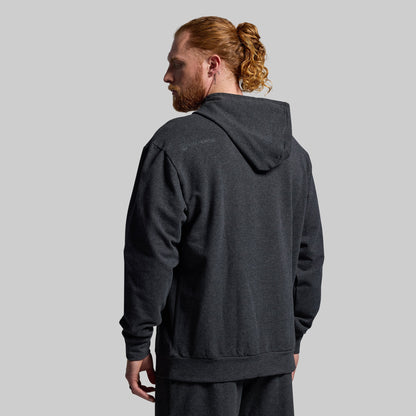 Man wearing a dark gray hoodie from behind on a light gray background
