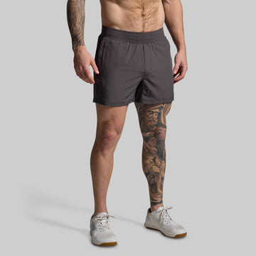 Man wearing gray shorts on a plain background