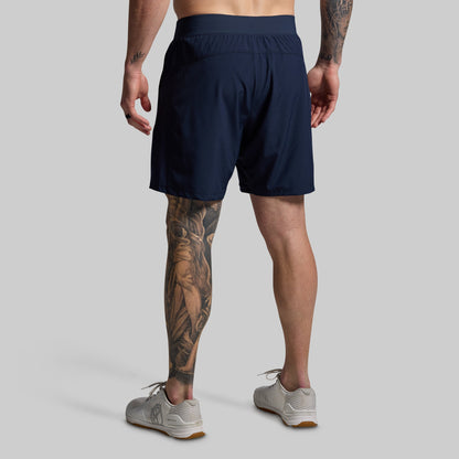 Person wearing navy shorts on a gray background
