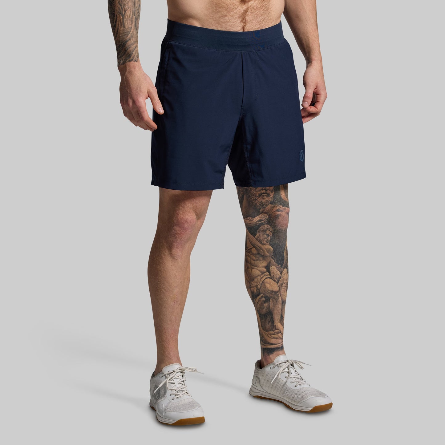 Person wearing navy shorts on a gray background
