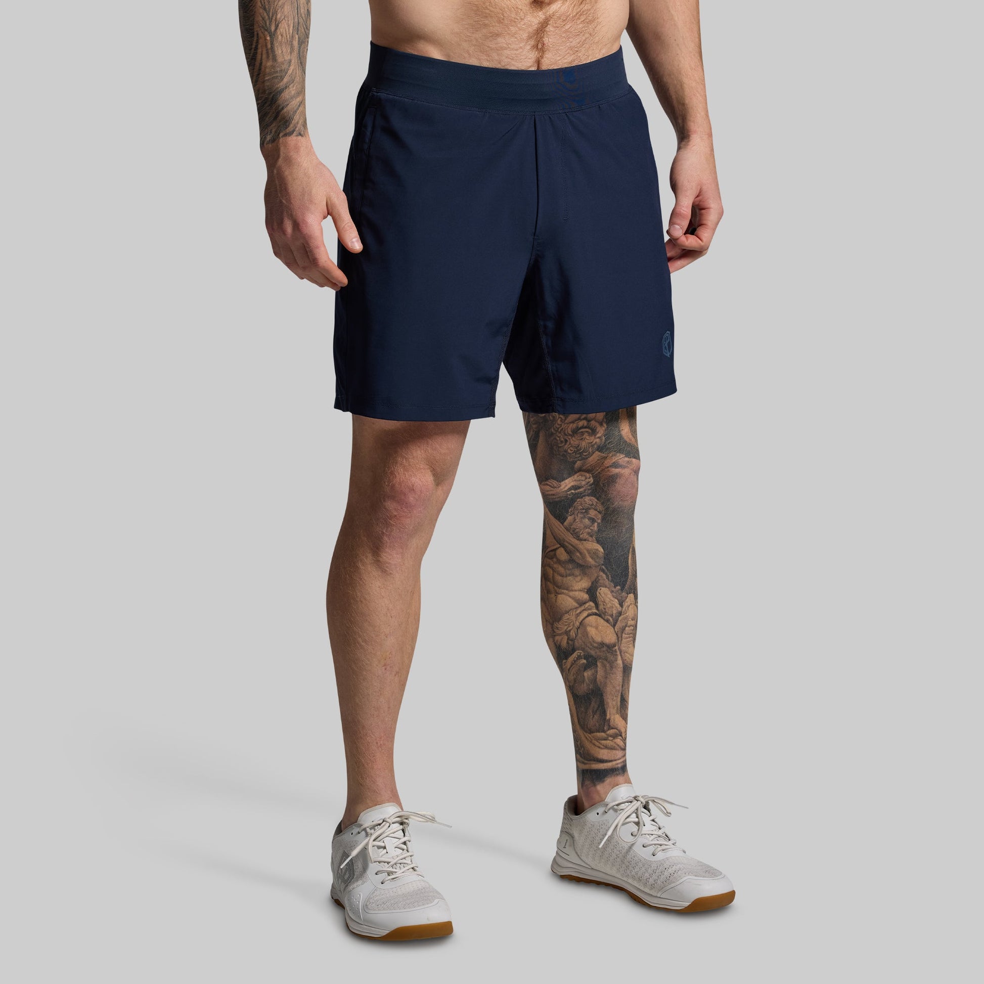 Person wearing navy shorts on a gray background