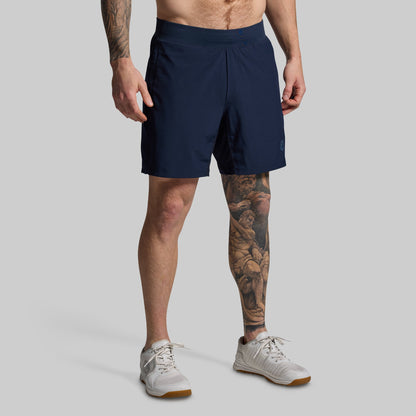 Person wearing navy shorts on a gray background