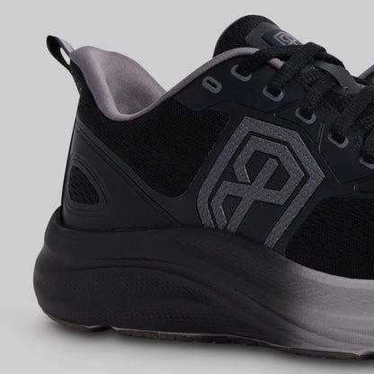 Black athletic shoe with a geometric logo on a gray background