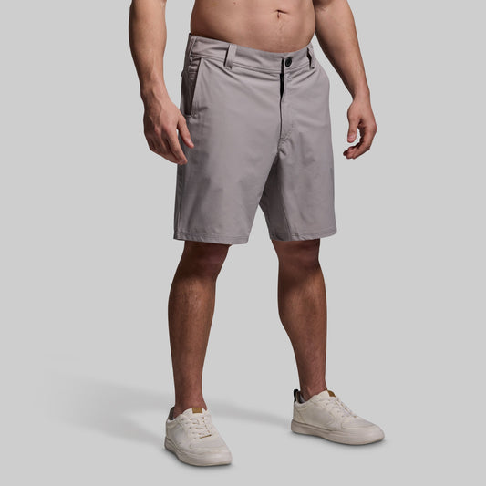 Person wearing gray shorts on a plain background