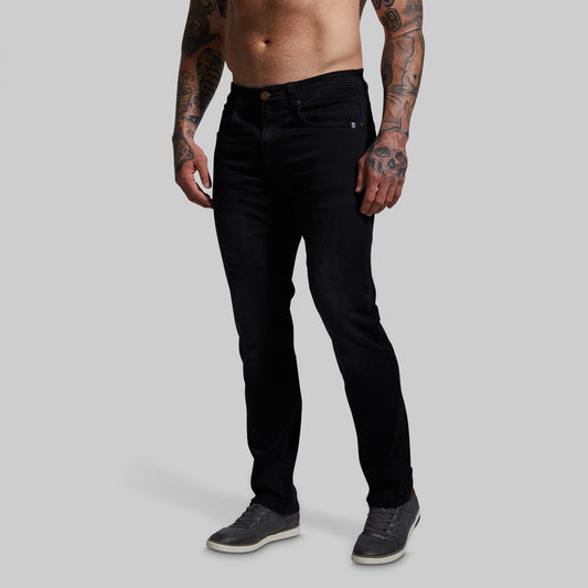 Man wearing black jeans on a gray background