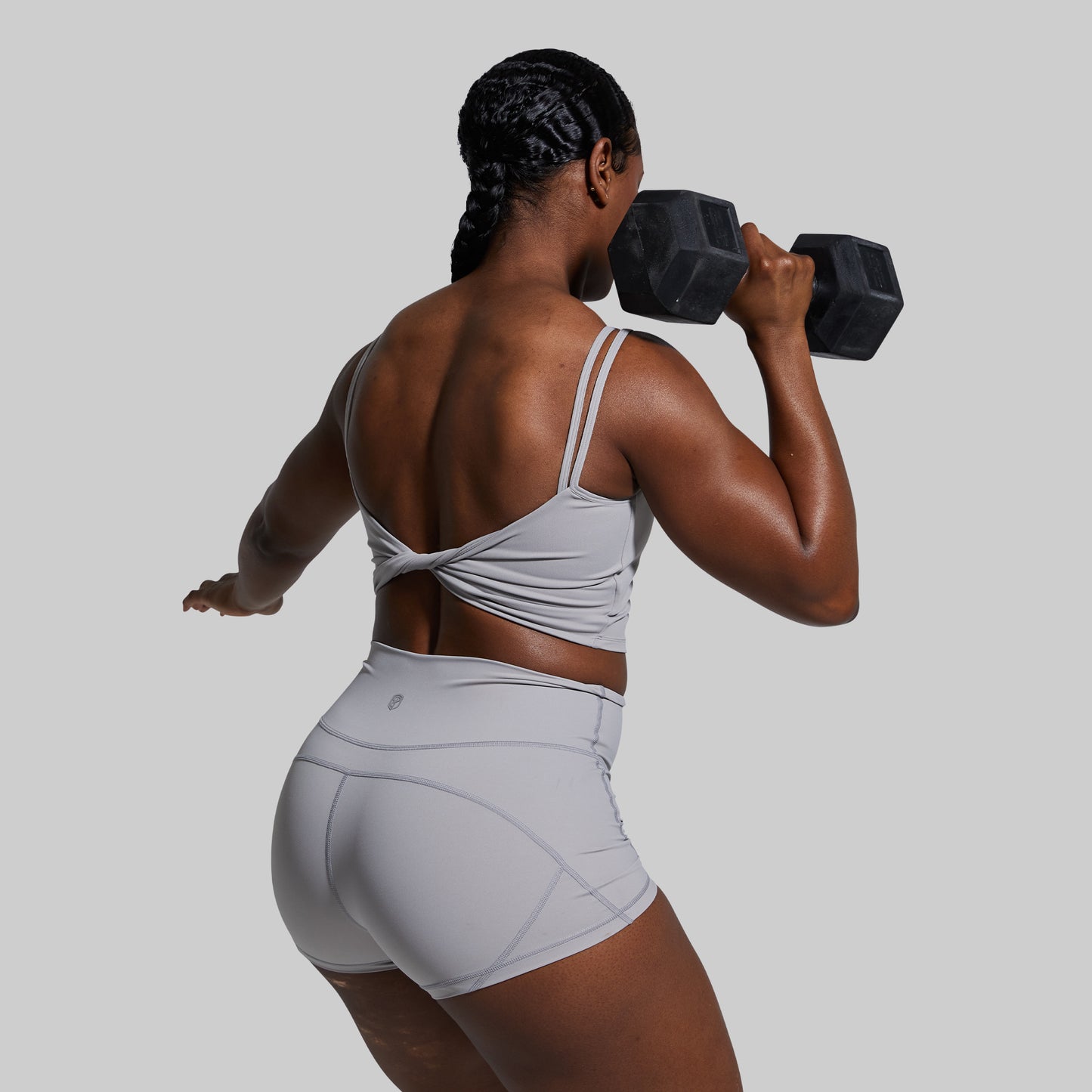 Person lifting a dumbbell on a plain background