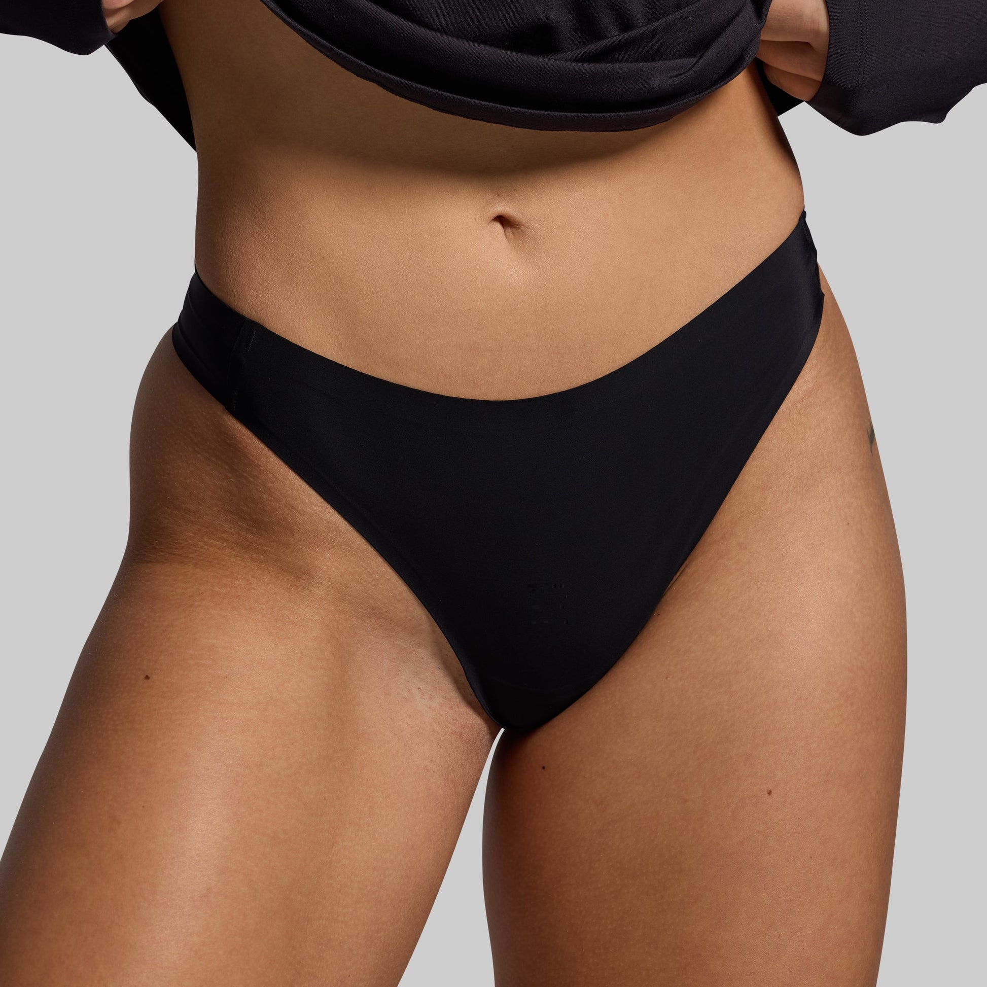 Black underwear worn by a person on a plain background