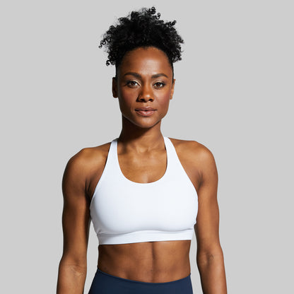 Woman wearing a white sports bra against a gray background