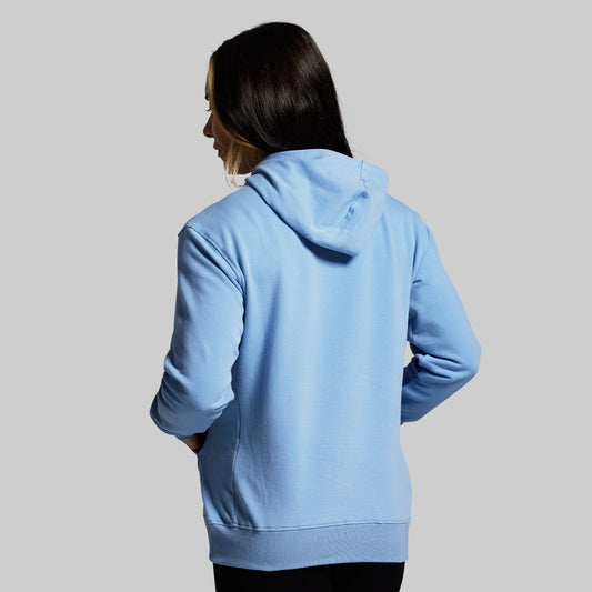 Person wearing a light blue hoodie on a gray background