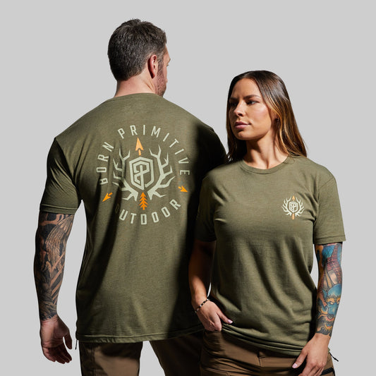 Two people wearing green t-shirts with a brand logo on a gray background