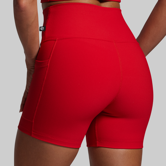 Red athletic shorts worn by a person on a gray background