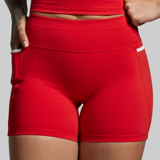 Red athletic shorts worn by a person on a gray background