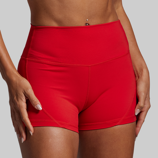 Red athletic shorts worn by a person on a gray background