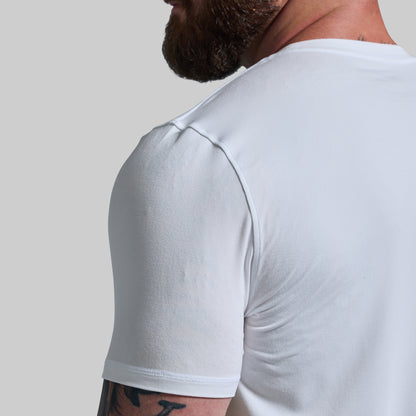 Man wearing a plain white t-shirt against a light gray background
