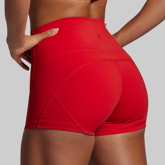 Red athletic shorts worn by a person on a gray background