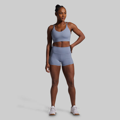 Woman wearing a light blue athletic outfit on a gray background