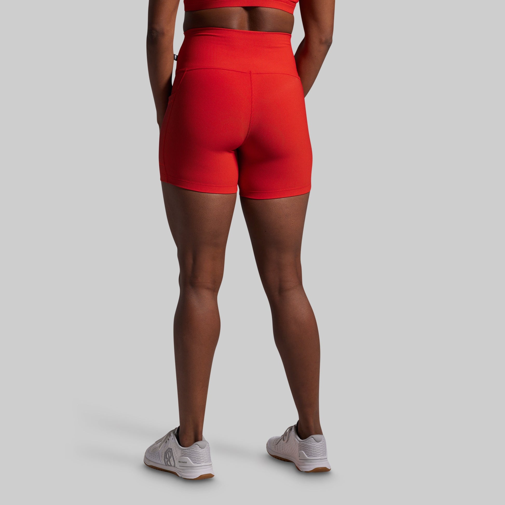 Person wearing red athletic shorts on a gray background