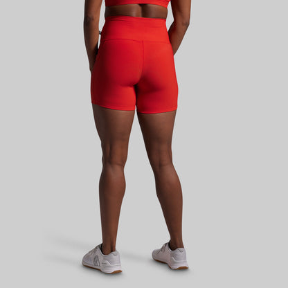 Person wearing red athletic shorts on a gray background