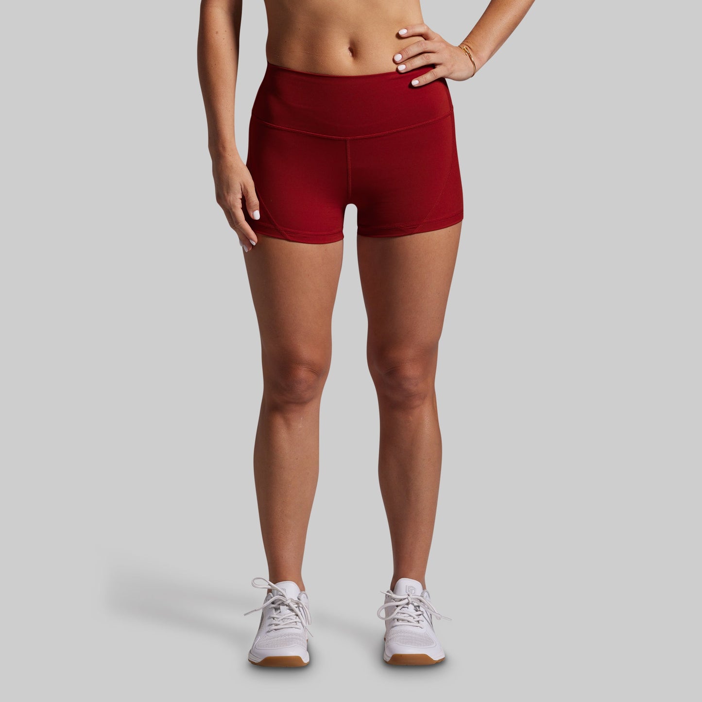 Person wearing red athletic shorts on a gray background
