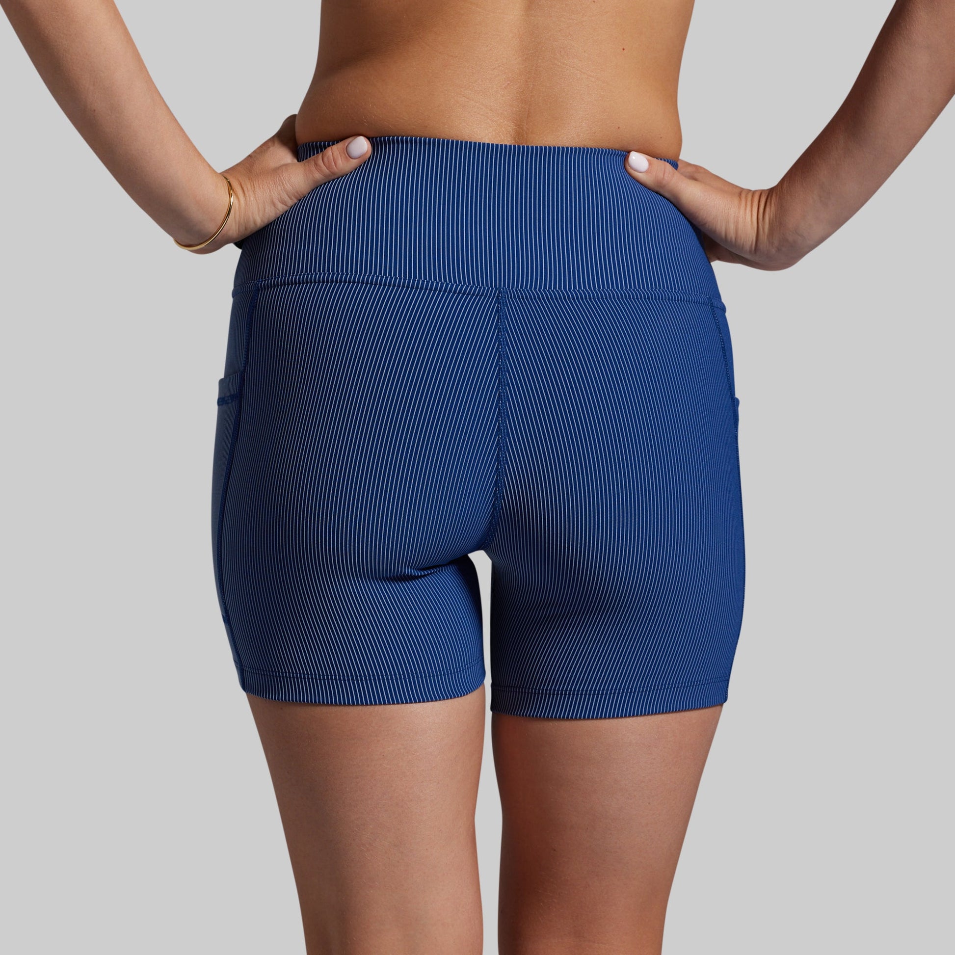 Blue athletic shorts worn by a person on a gray background