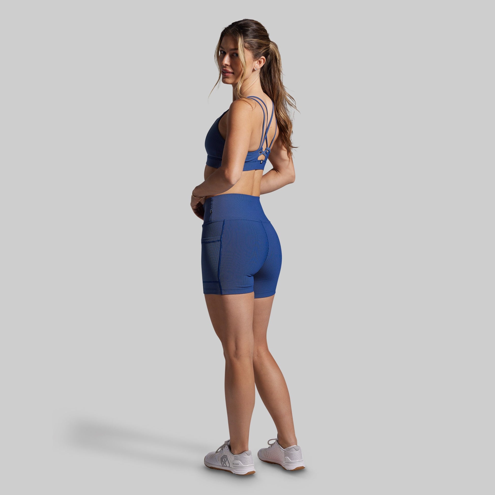 Woman wearing a blue athletic outfit on a gray background