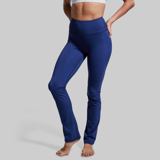 Person wearing blue yoga pants on a gray background