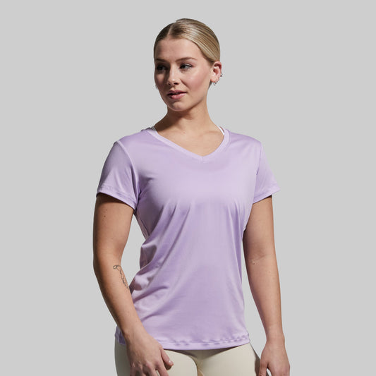 Woman wearing a light purple t-shirt against a plain background