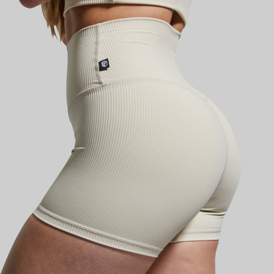 Beige ribbed high-waisted shorts on a plain background