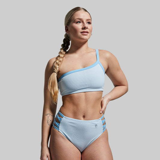 Woman wearing a light blue bikini against a plain background