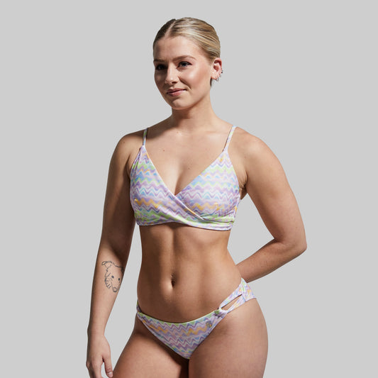 Woman wearing a colorful bikini against a plain background