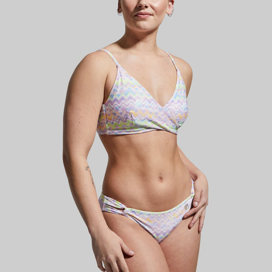 Woman wearing a colorful bikini set against a plain background